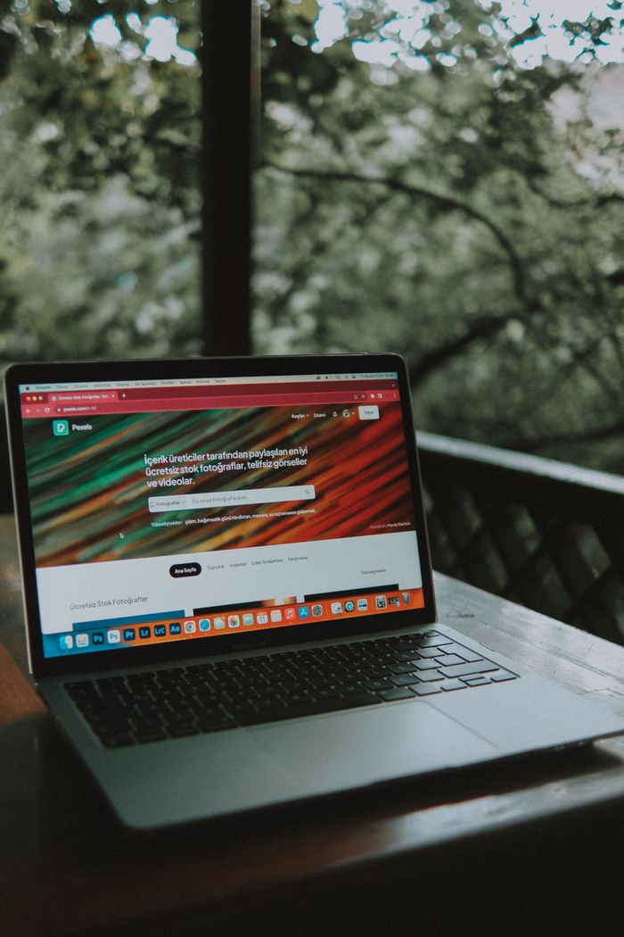 Services Open laptop on a wooden table with a scenic outdoor view.